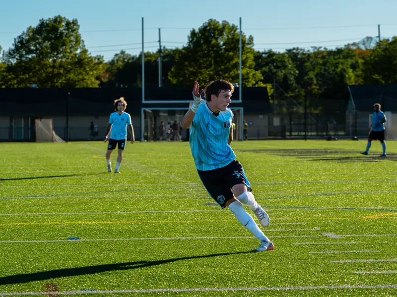 A Detroit Metro FC player celebrates on an outdoor pitch